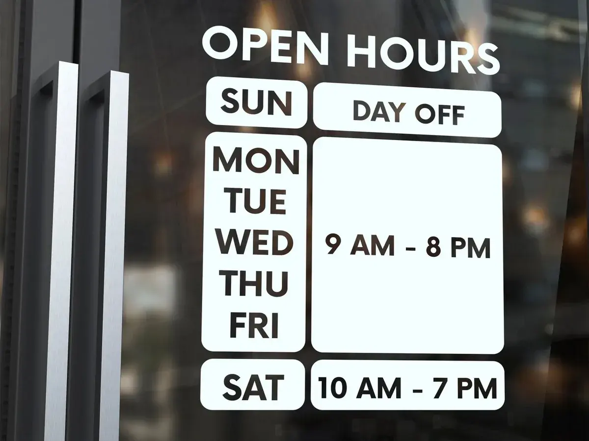 Shop opening-hours sign before the edit. The hours read: 9 AM - 8 PM